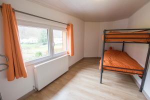 ein Schlafzimmer mit einem Etagenbett und einem Fenster in der Unterkunft l'oiseau d'eau in Bouillon