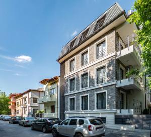 un bâtiment avec des voitures garées devant lui dans l'établissement Vila Cotroceni Boutique Apartments, à Bucarest