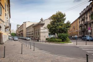 una strada cittadina vuota con auto parcheggiate sulla strada di Milano Suite - Downtown a Milano