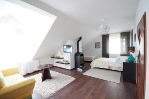 a white bedroom with a bed and a couch at Koral in Władysławowo