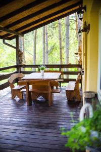 una terraza de madera con mesa de picnic y bancos en Kurort Mirowice, en Mirowice