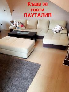 a living room with a couch and a coffee table at Guest House Pautalya in Kyustendil