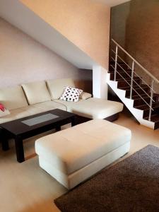 soggiorno con divano, tavolo e scale di Guest House Pautalya a Kjustendil