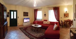 インペリアにあるCasa vacanze Cristinaのリビングルーム(赤いソファ、テレビ付)