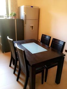 a dining room table with chairs and a refrigerator at Guest House Pautalya in Kyustendil
