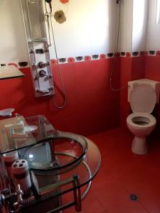 a red bathroom with a toilet and a glass sink at Guest House Pautalya in Kyustendil +4 photos
