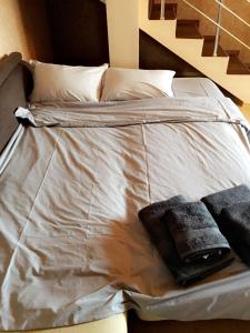 un letto con lenzuola e cuscini bianchi di Guest House Pautalya a Kjustendil