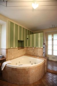 a large bathroom with a tub and a large mirror at Relais Villa Margherita in Oggebbio