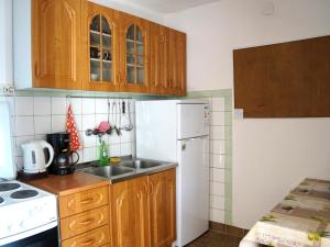 cocina con armarios de madera y nevera blanca en Apartments Feral, en Baška Voda