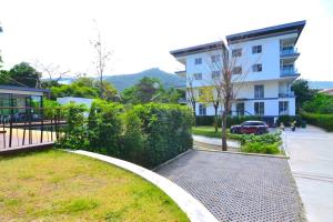 a hedge in front of a building with a driveway at The Bleu condo unit in Chaweng