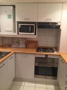 a kitchen with a microwave and a stove top oven at San Alfonso del Mar Puerto del Sur in Algarrobo +9 photos
