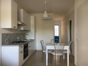 a kitchen with a table and a white table and chairs at Favignana Holidays in Favignana