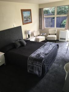 1 dormitorio con 1 cama y sala de estar en Mount View Motel Hawera, en Hawera