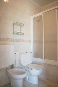 a bathroom with a white toilet and a sink at Hostal Juan Carlos in Carboneras