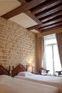 a bedroom with a brick wall with a bed and a window at Tonic Hôtel du Louvre in Paris