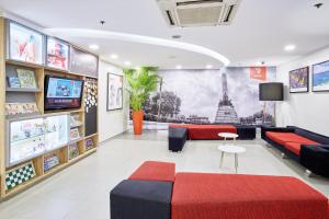 una sala de espera con sofá y TV en Red Planet Manila Malate Mabini en Manila