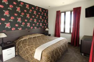 a bedroom with a bed with a floral wall at The Famous Grouse Hotel in Lincoln