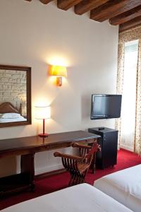 a hotel room with a desk and a tv at Tonic Hôtel du Louvre in Paris