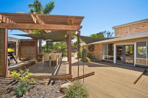 una terraza de madera con una hamaca en una casa en Paw Up Villa - entertainer delight, en Rye