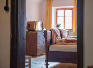 a bedroom with a tv on a dresser and a chair at Salzhaus in Hallstatt +23 photos