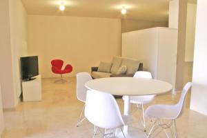 a living room with a table and chairs and a couch at L' Escala Resort in L'Escala