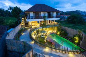 a villa with a swimming pool at night at Athaya Ubud in Ubud