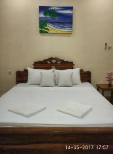 a bed with two white towels on top of it at Chika House in Gili Trawangan