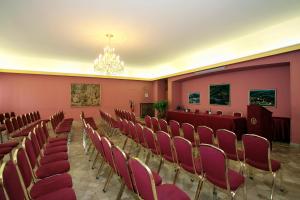 a room with pink walls and chairs and a chandelier at Hotel De Paris in Terni