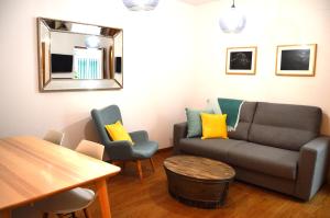 een woonkamer met een bank en twee stoelen bij La Casa del Reloj Cadiz in Cádiz