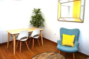 een eettafel met 4 stoelen en een geel kussen bij La Casa del Reloj Cadiz in Cádiz