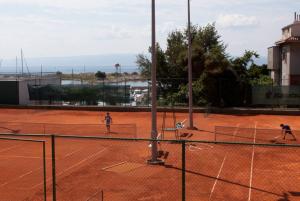 two people playing tennis on a tennis court at Apartments Beautiful Sandy Beach in Split