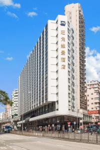 een groot wit gebouw aan de straatkant bij Metropark Hotel Mongkok in Hong Kong