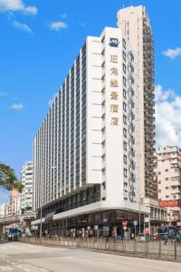 a large white building on the side of a street at Metropark Hotel Mongkok in Hong Kong