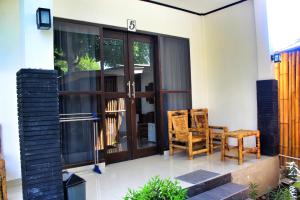 a house with a glass door and two chairs at Akalanka in Gili Trawangan