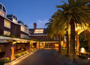 a courtyard with palm trees in front of a building at The Stanford Park Hotel in Menlo Park