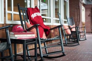 a group of chairs with a hat and books at The Stanford Park Hotel in Menlo Park