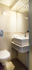 een badkamer met een wastafel, een toilet en een spiegel bij Vinger Hotell in Kongsvinger