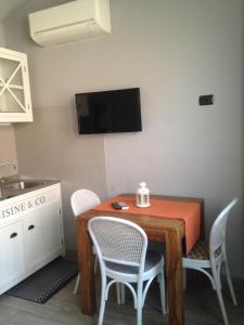 サント・ステーファノ・アル・マーレにあるAppartamento Ambraのキッチン(テーブル、椅子、壁掛けテレビ付)