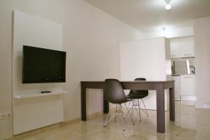a living room with a table and a television at L' Escala Resort in L'Escala