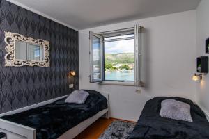 sypialnia z 2 łóżkami i oknem w obiekcie Villa Jidro w Trogirze