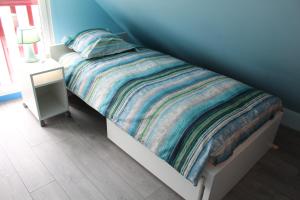 - une chambre avec un lit et une couette colorée dans l'établissement La Grange Du Festel, à Oneux