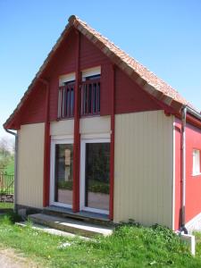 une petite maison rouge et blanche dans l'établissement La Grange Du Festel, à Oneux