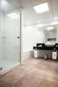 Playitas Villas - Sports Resort في لاس بلايتاس: حمام مع دش وحوض استحمام ومغسلة