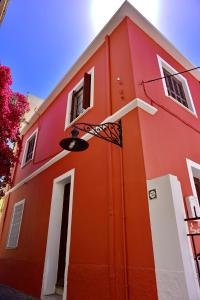 een rood gebouw met een deur en een raam bij Villa Mariza 1920 in Rhodos-stad