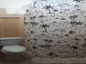 a bathroom with a black and white shower curtain with palm trees at Patong Rose Guest House in Patong Beach