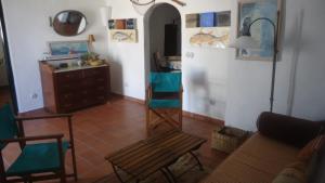 salon z kanapą i krzesłem w obiekcie ESGLESIA 4 by SOM Menorca w mieście Fornells