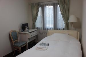 a bedroom with a bed and a desk and a chair at La Isla Tasse in Yakushima