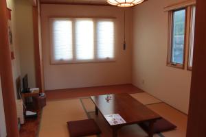 sala de estar con mesa y ventana en La Isla Tasse en Yakushima