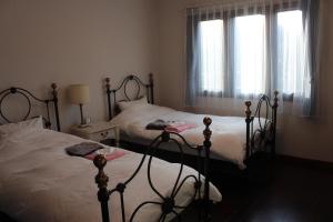 a bedroom with two beds and two windows at La Isla Tasse in Yakushima