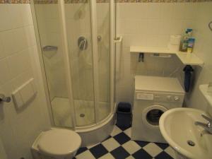 een badkamer met een douche en een wasmachine bij Hafenblick-City Apartment Husum in Husum